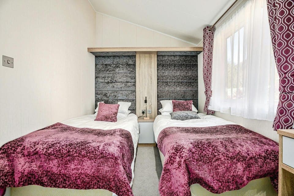 Bedroom with two single beds, small bedside unit and lamp