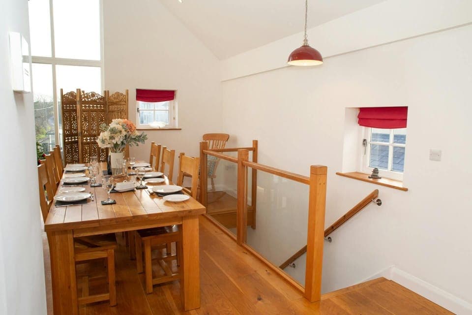 Dining table laid with crockery and glassware near upstairs landing