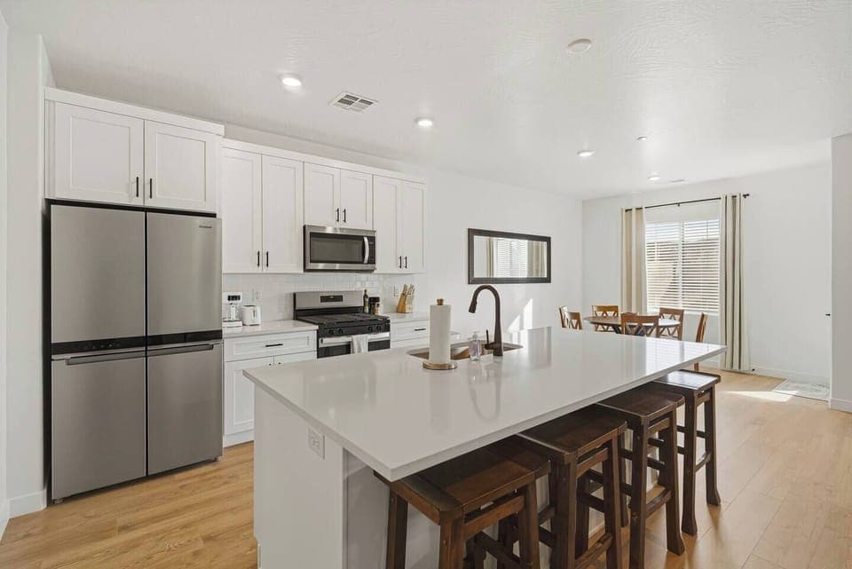 Modern kitchen with large island seating and open dining area.