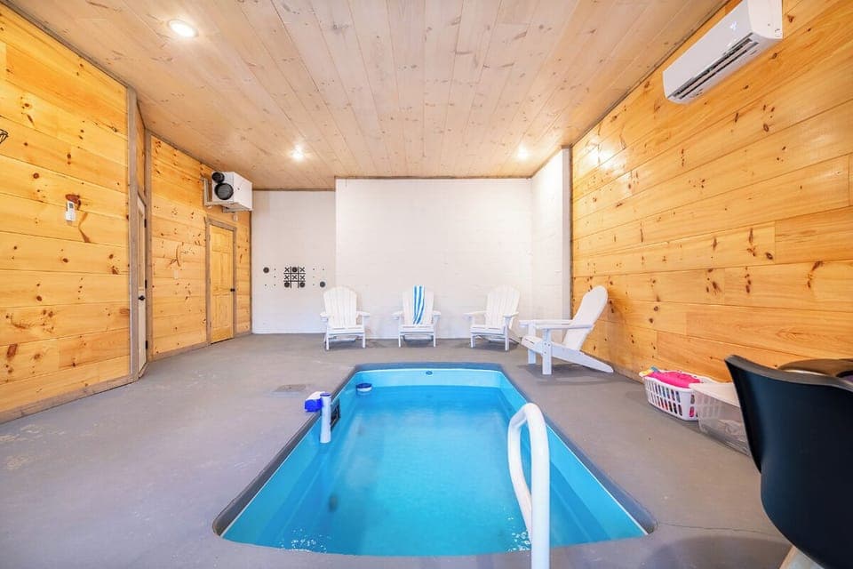 Dive into your private indoor pool surrounded by warm wood walls and comfortable seating—perfect for year-round relaxation.