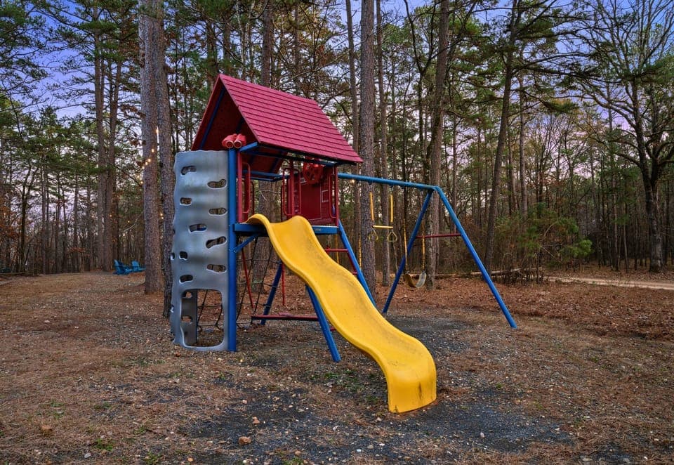 Tucked into the yard, the children’s playset offers a fun outdoor space where kids can climb, slide, and play while surrounded by nature.
