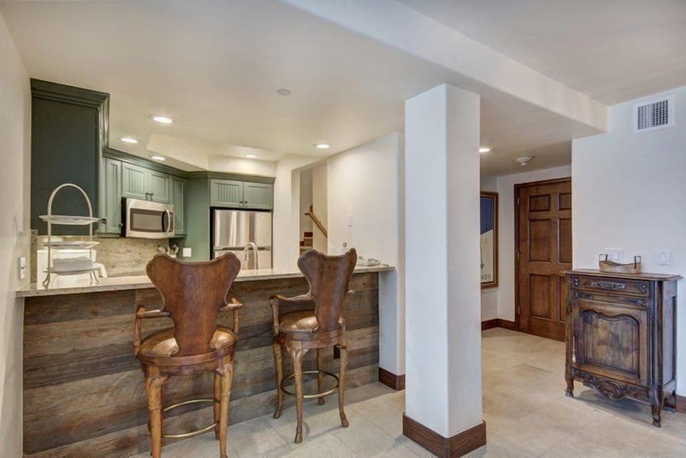 Entertain guests in the open kitchen and bar area, featuring modern appliances, a spacious countertop, and stylish bar seating for a casual dining experience.