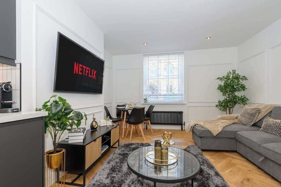 Living room with large screen TV , sofa bed and table for 4