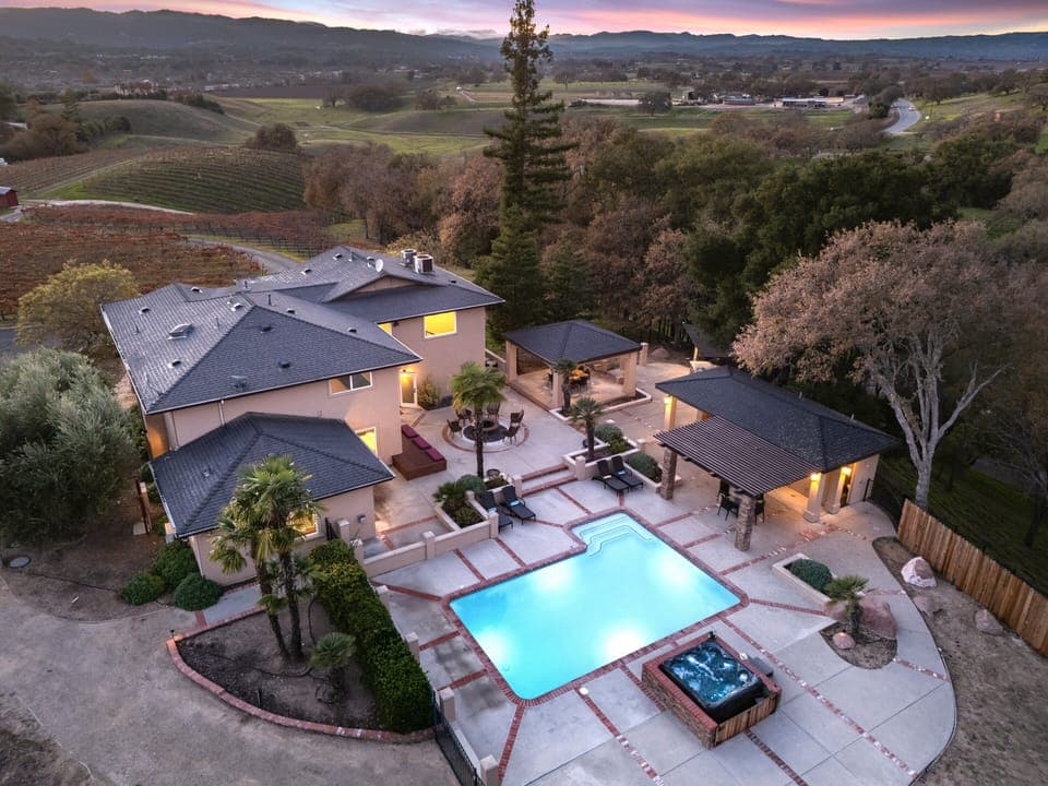 Evening aerial view of the main residence and pool.