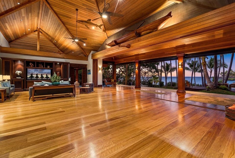 Step into your spacious living sanctuary with soaring wooden ceilings and ocean views through floor-to-ceiling windows.