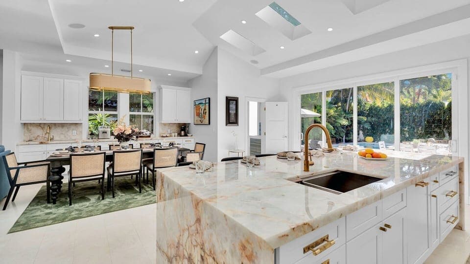 Your gourmet kitchen features marble countertops and premium appliances, perfect for preparing meals while enjoying garden views through expansive windows.