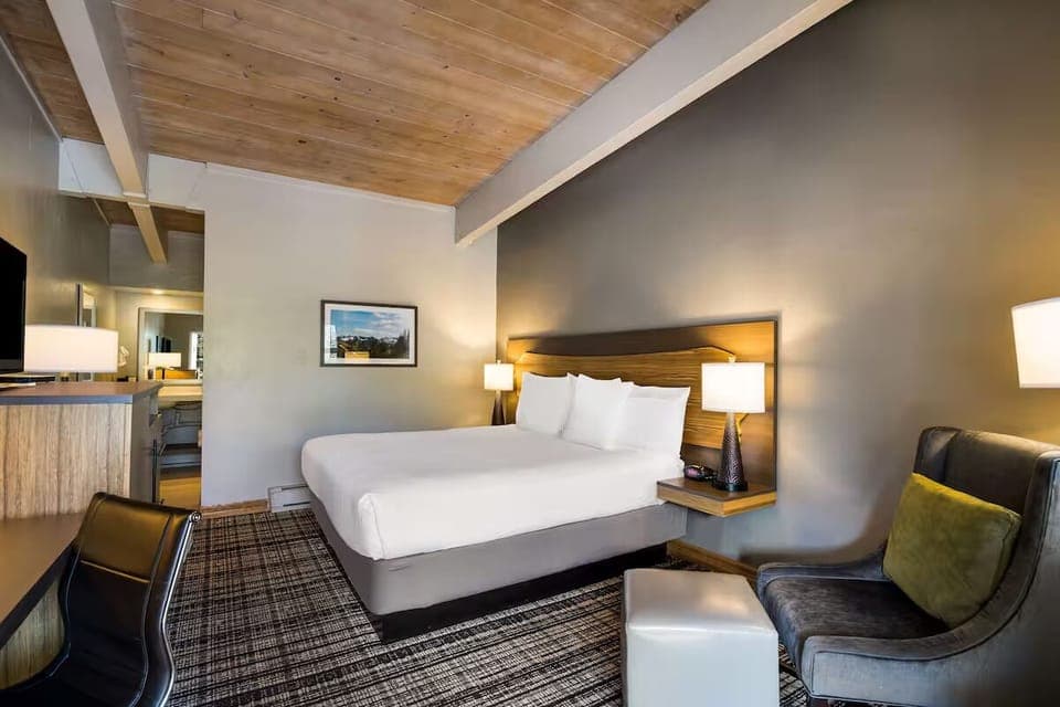 Unwind in a cozy king bed under warm wood ceilings.