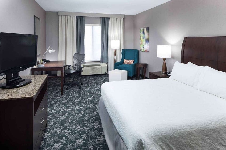 King bed room with desk, TV, and seating space