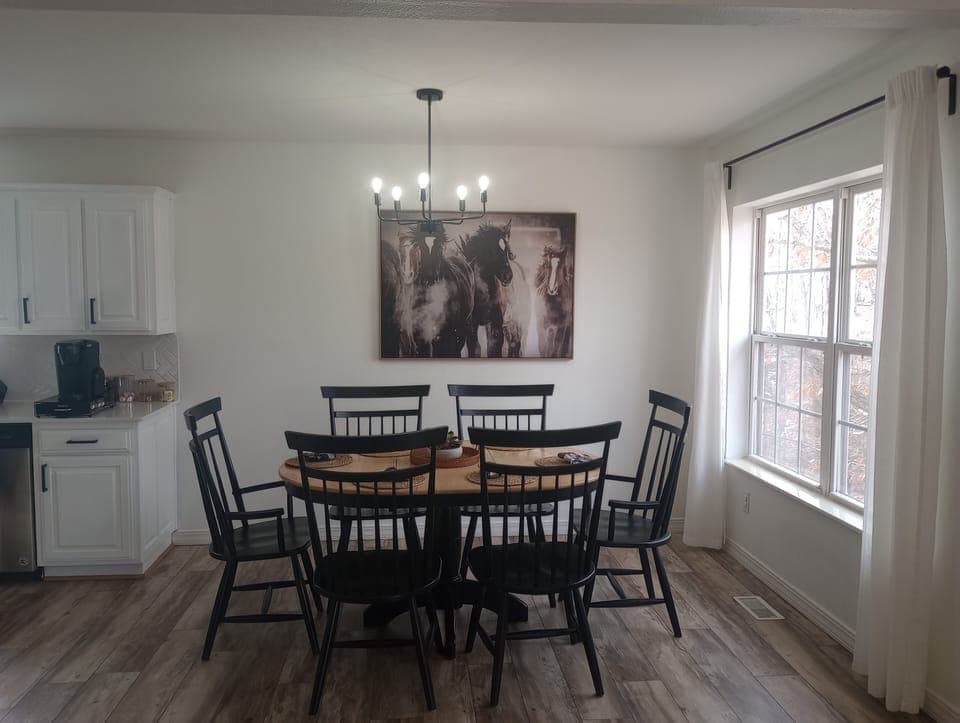 Sunny dining nook for six beside sleek kitchen and coffee bar