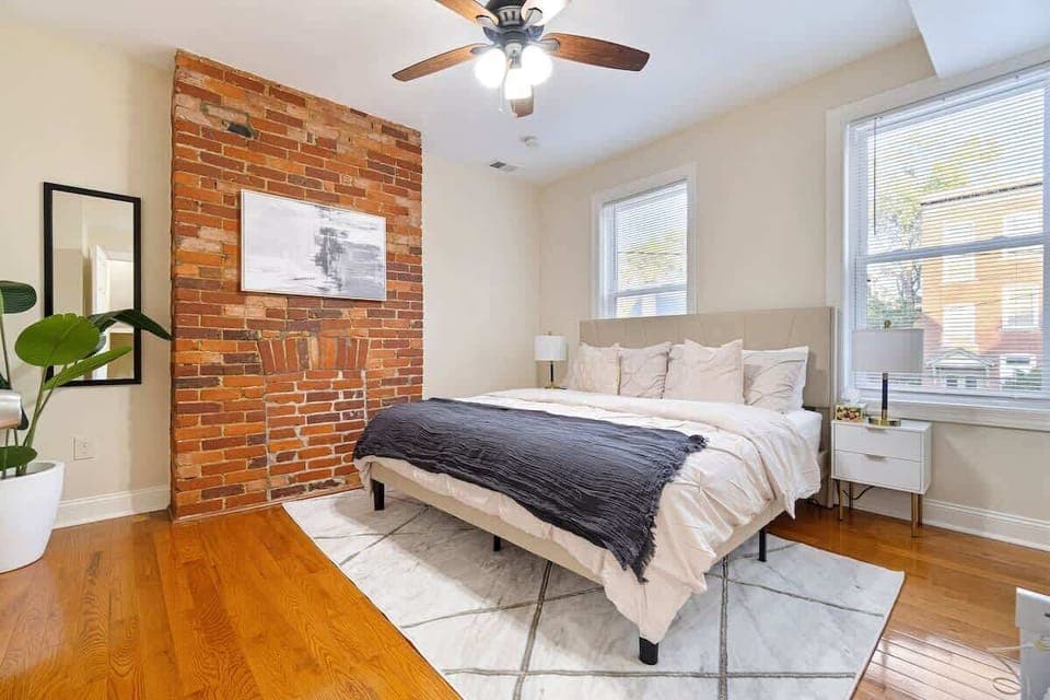 Cozy bedroom with a king-size bed and charming exposed brick accent wall adding warmth and character.