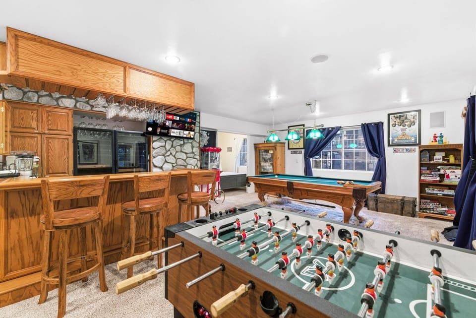 Game room with bar, pool table, foosball, popcorn, and games for all ages.