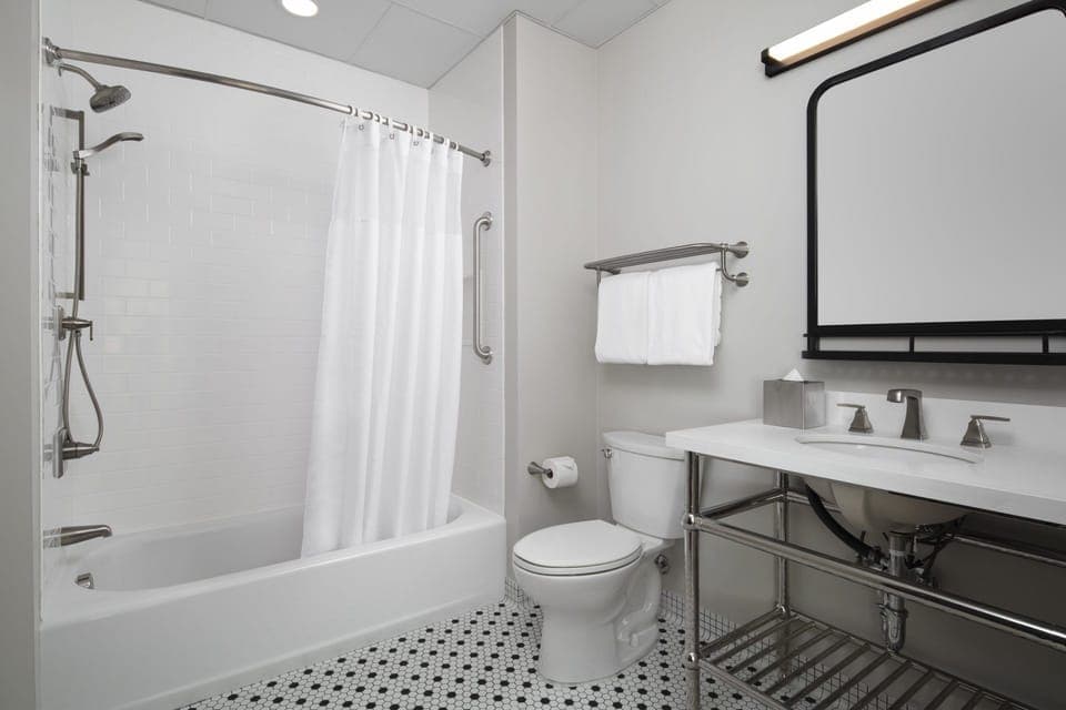Refresh in a spotless bath with bright lighting and tub.