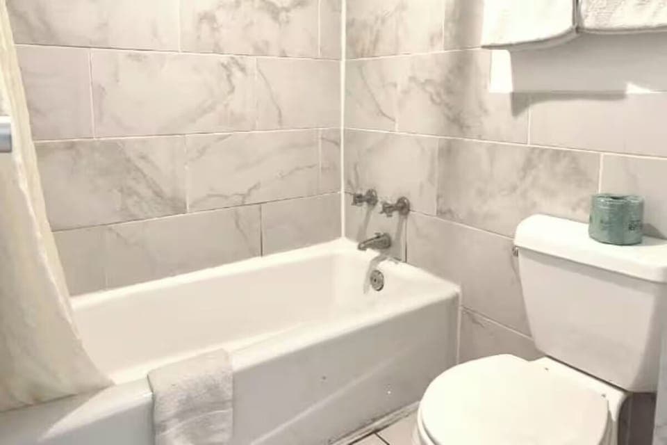Soak and reset in a clean, tiled shower-tub combo.