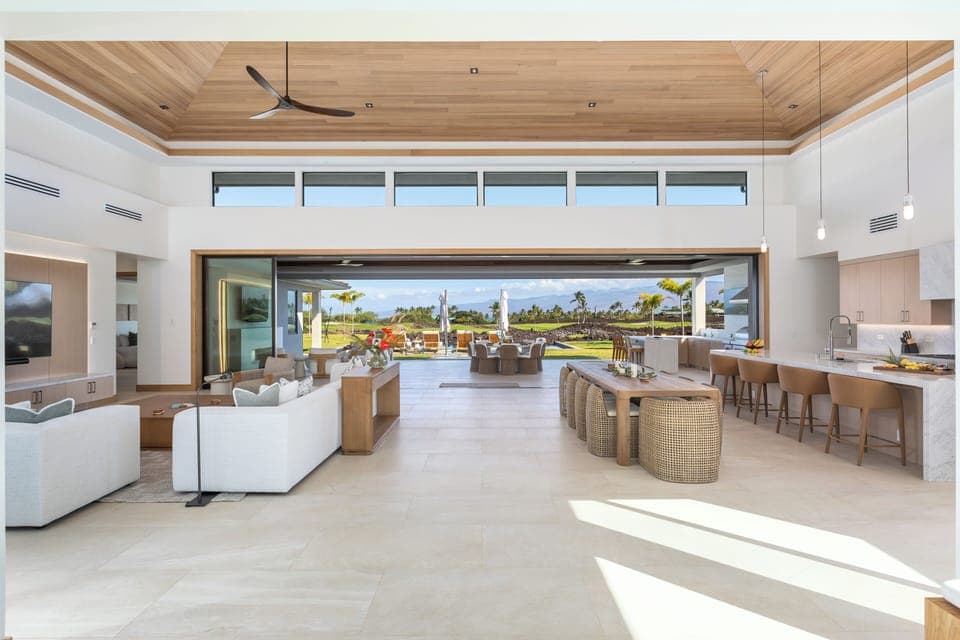 Relax in your stunning open-concept living space where indoor luxury meets outdoor paradise through soaring glass doors.