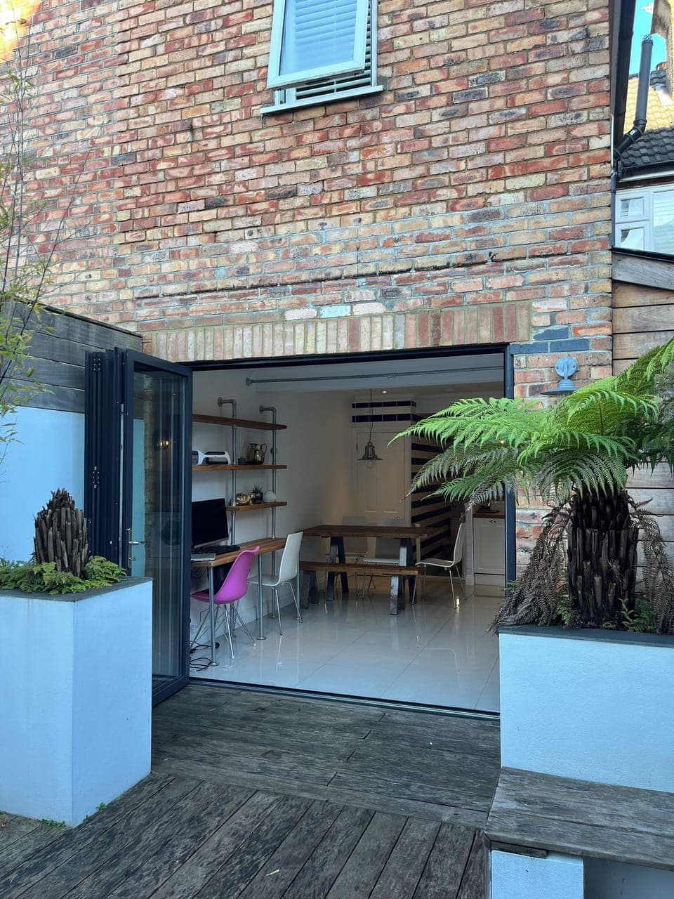 Courtyard garden and bifold doors open to kitchen diner