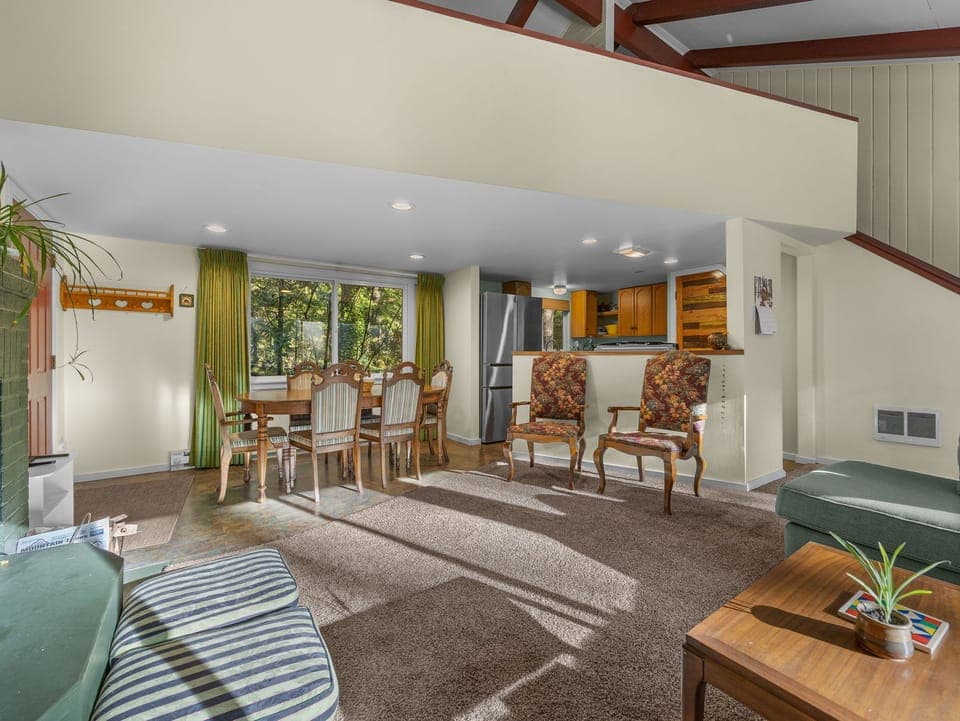 Relax in your spacious open-plan retreat where natural light streams through large windows onto warm wood floors and comfortable seating.