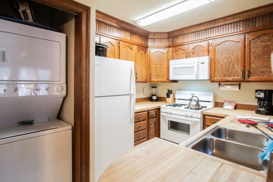 The full kitchen boasts traditional wooden cabinetry and modern appliances, making it easy to prepare delicious meals at home.