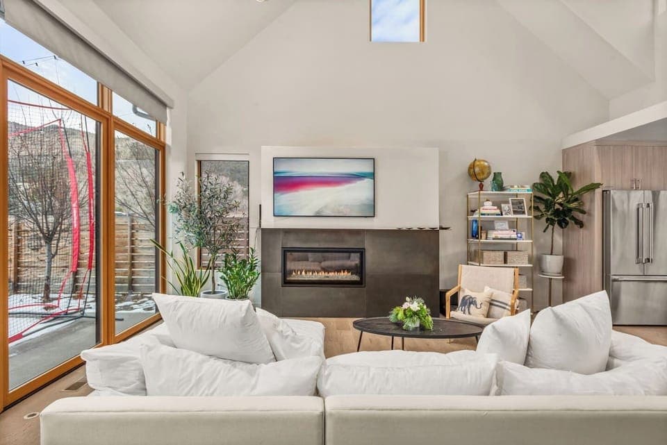 Open Kitchen/Living Area/Dining Area with High Ceilings, TV, Fireplace & Large Windows & Sliding Doors to Backyard