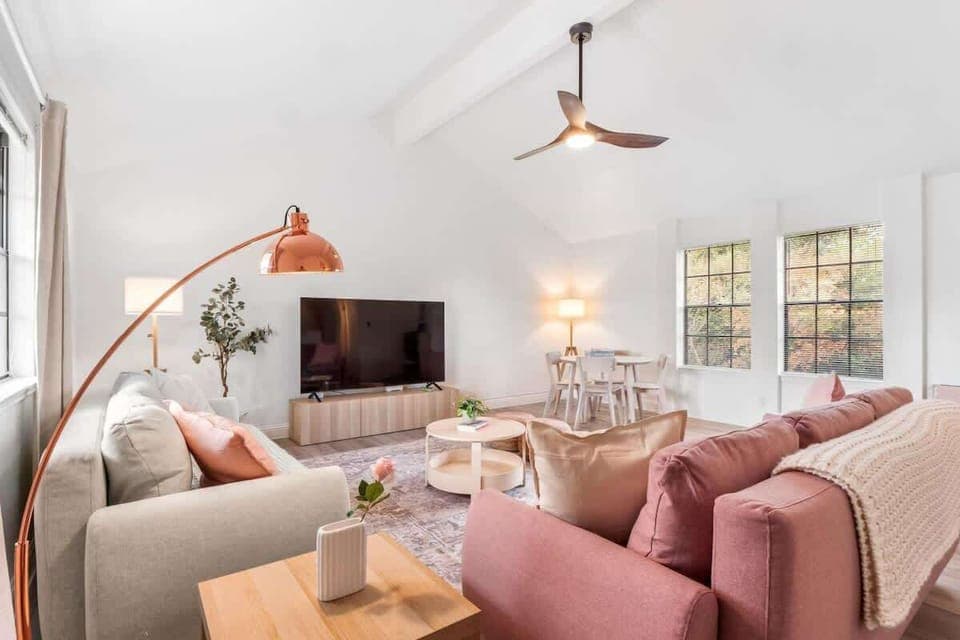 Bright and spacious second living room with vaulted ceilings, a 65" TV, and stylish seating. Both couches convert into comfortable beds, making this space perfect for movie nights, lounging, or providing extra sleeping options for family and friends.