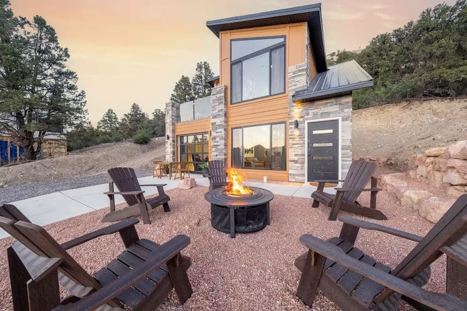 An exterior view of our home, the courtyard, the Adirondack chairs and fire pit 