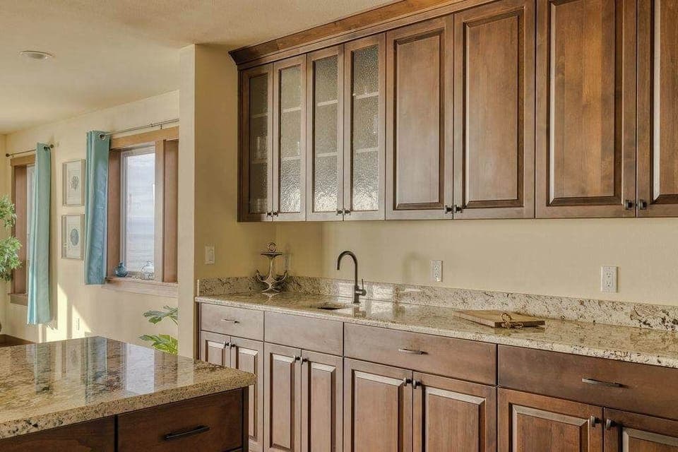 Elegant frosted glass cabinet faces allow for a soft, airy look while keeping your kitchen essentials neatly tucked away.