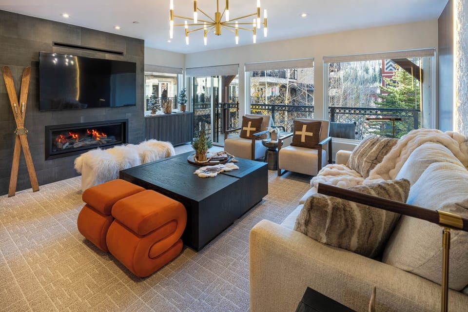 Unwind by your cozy fireplace in this stylish living room, where plush seating and mountain views create the perfect après-ski retreat.