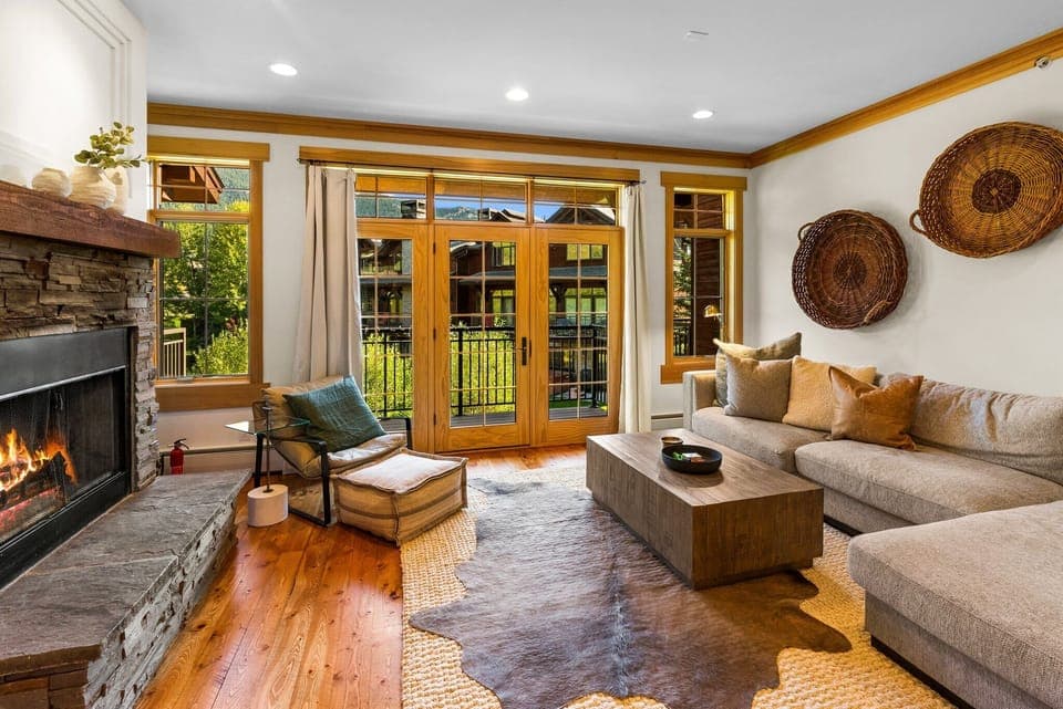 Living room: Wood-burning fireplace, 55" Smart TV, sectional sofa, patio access