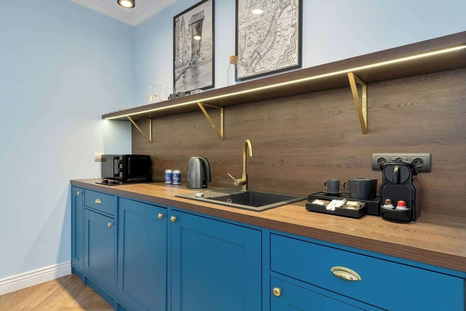Fully equipped kitchen with blue cabinets and worktop.