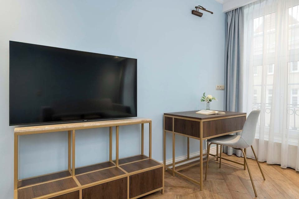 Living room TV area with console and desk.