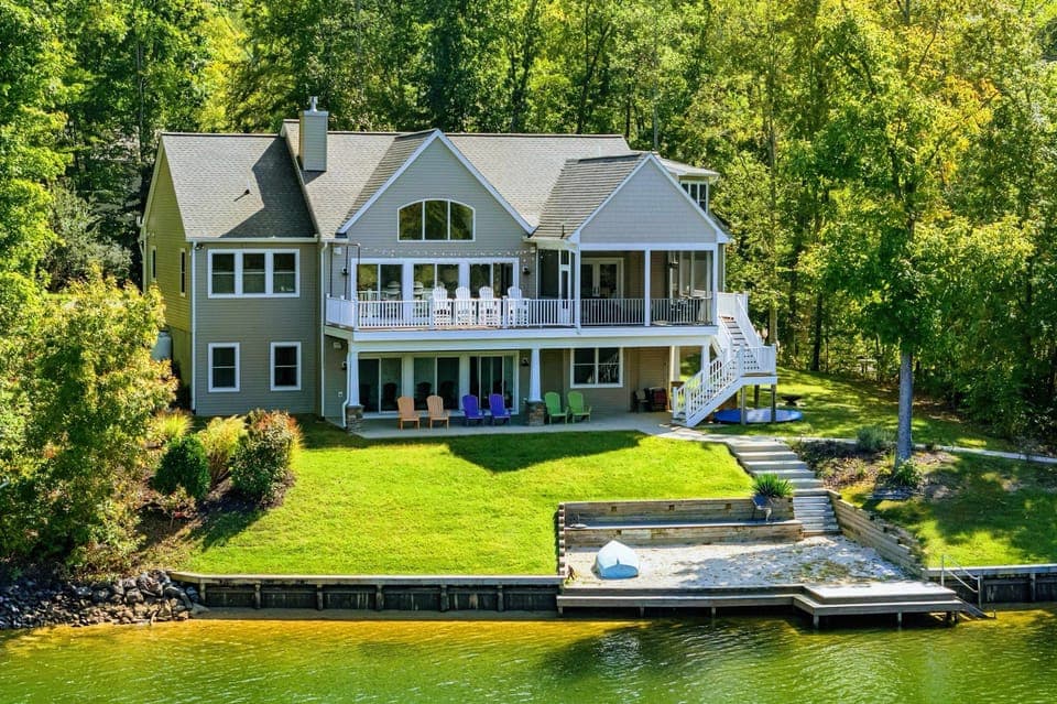 Exterior - Stunning craftsman lakefront home with stone accents and a welcoming covered porch.