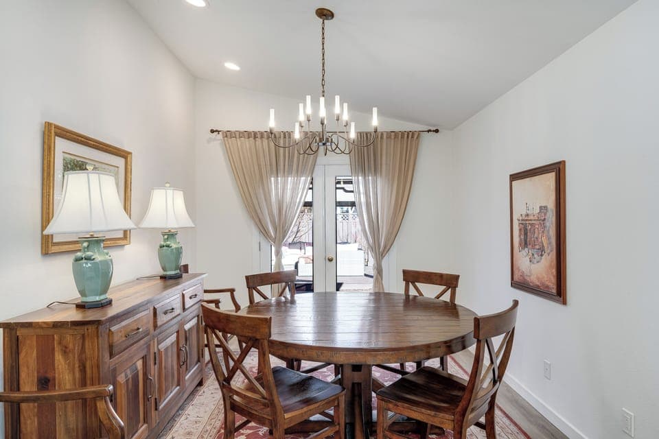 Gather around your elegant dining table beneath the warm glow of candlelit chandelier for memorable meals with loved ones.