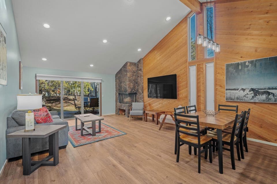 Relax in your stylish open-concept living space with soaring ceilings, cozy fireplace, and dining for six.