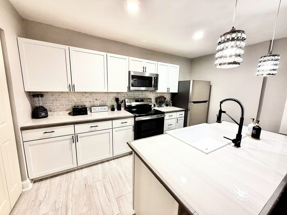 Sleek countertops, farmhouse sink, and modern fixtures make this kitchen both functional and beautiful for extended stays.