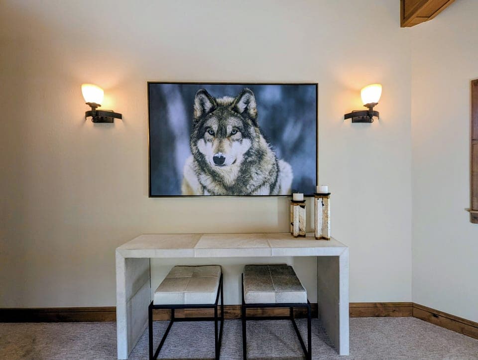Cozy up for movie nights on your modern white console beneath warm sconce lighting and stunning wildlife art.