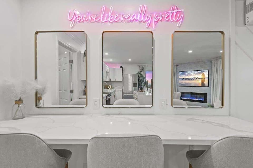 A stylish vanity setup with a glowing neon reminder that you're like, really pretty.