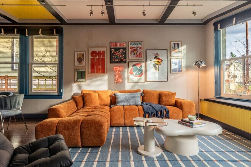 Sun-filled living room with a statement velvet sofa, large windows, and curated art for a warm, stylish retreat.