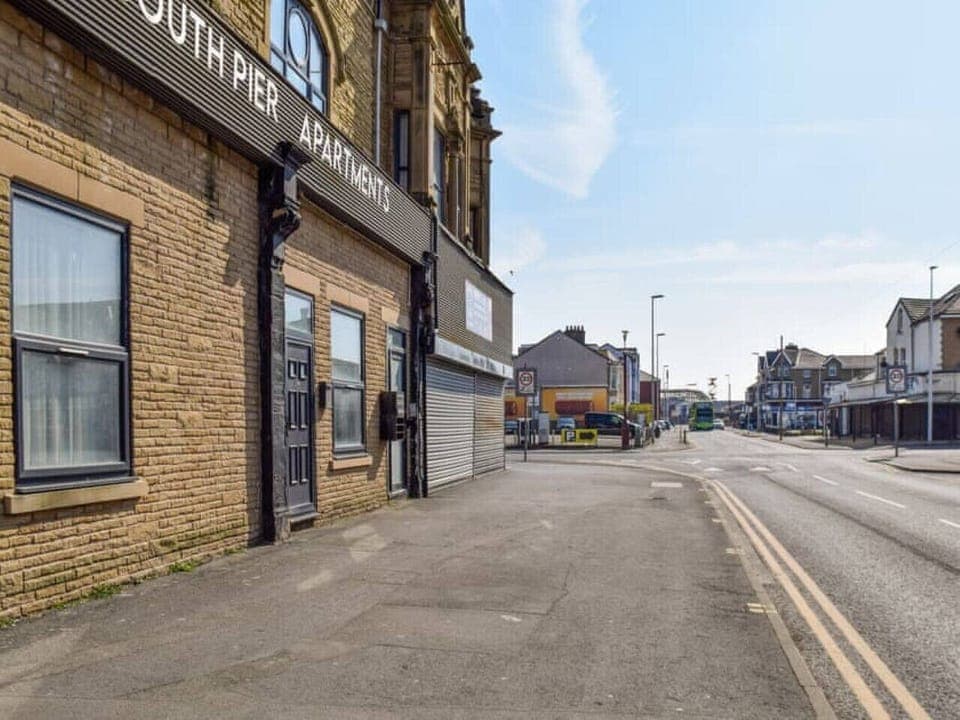 Step outside to a wide pavement view along the road beside the building.