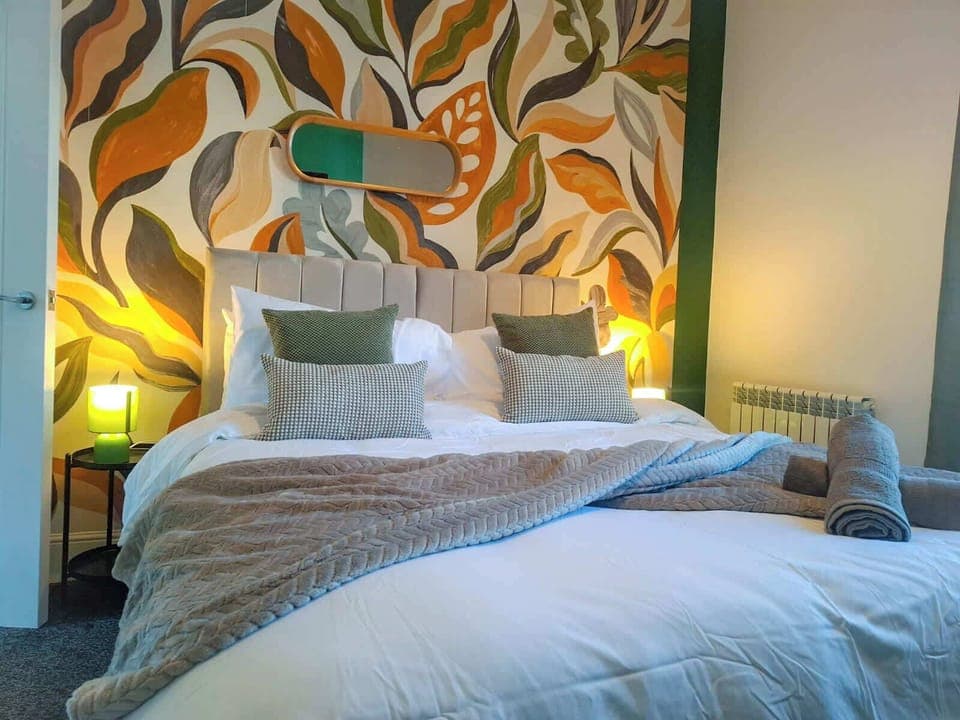 Comfortable king bedroom with stylish feature wall, quality bedding and soft lighting for a great night’s sleep after work or travel.