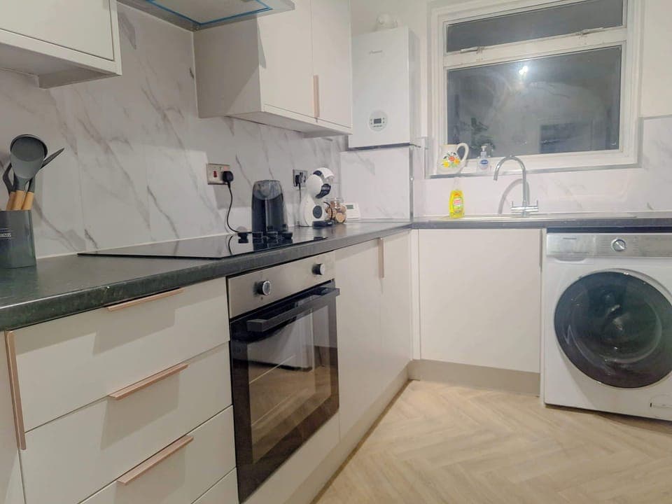 Fully equipped modern kitchen with oven, hob, fridge freezer and washing machine for longer stays.