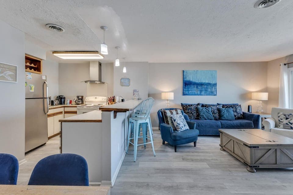Unwind in your stylish open-concept space where coastal blues meet modern comfort—perfect for cooking, relaxing, and making vacation memories together.