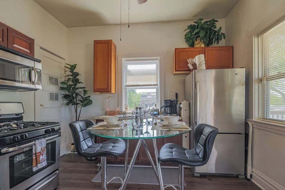 Modern kitchen featuring stainless appliances, warm wood cabinets, & bar seating.