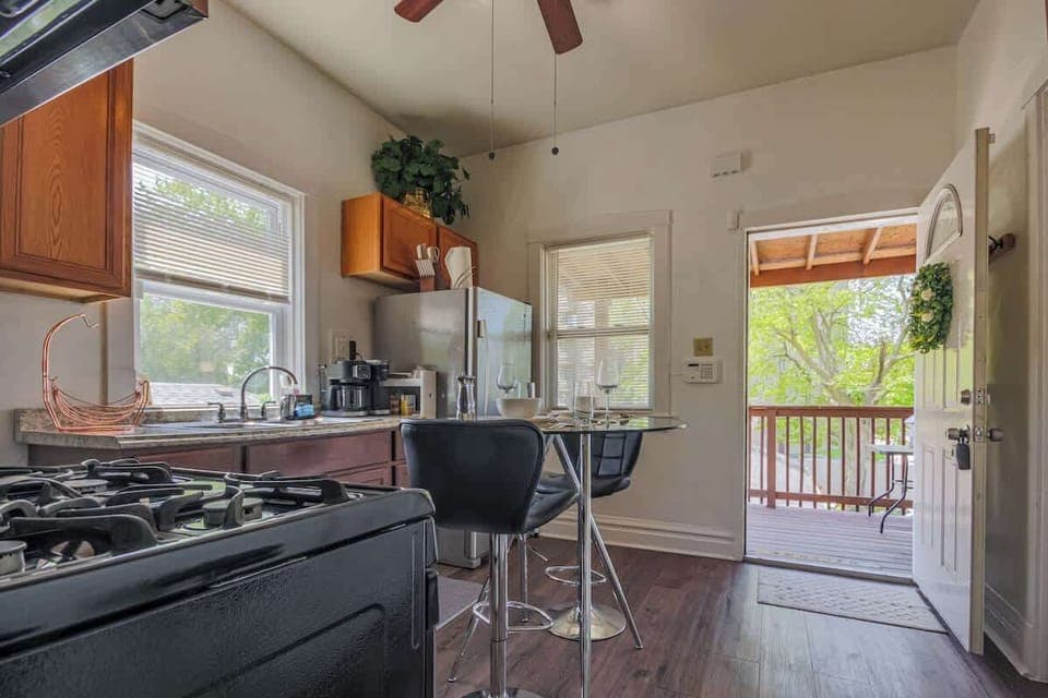 Sleek kitchen angle w/ dining table, modern fixtures, & natural light.