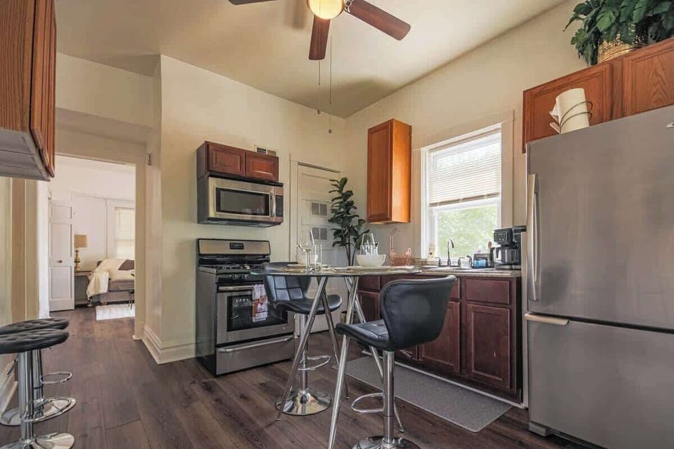 Clean-lined kitchen w/ open shelving, bright light, & a welcoming layout for meals.