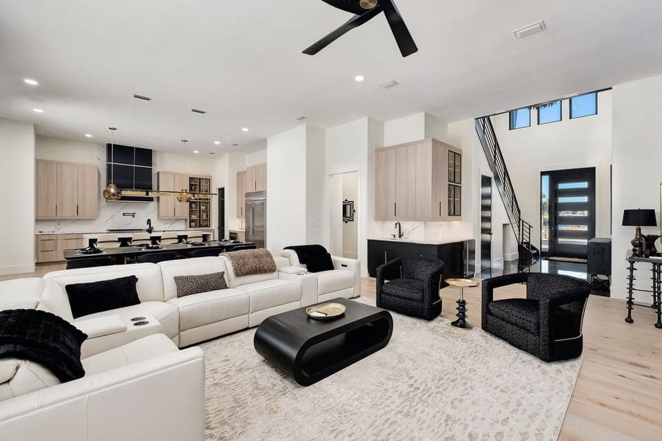 Step into your sophisticated open-concept retreat where sleek design meets comfort. Relax on plush white sofas while enjoying the modern kitchen's seamless flow.