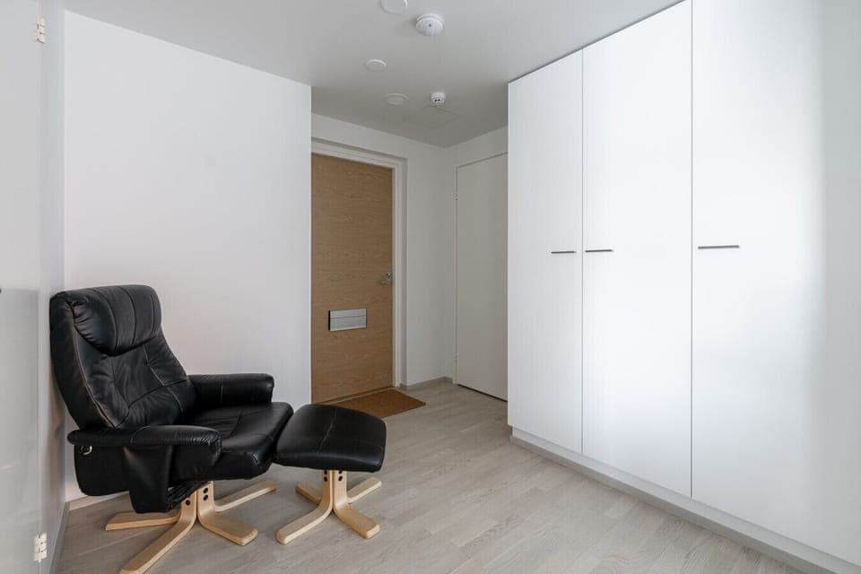 A functional and welcoming entryway featuring a comfortable leather recliner—the perfect spot to kick off your shoes and unwind the moment you arrive.