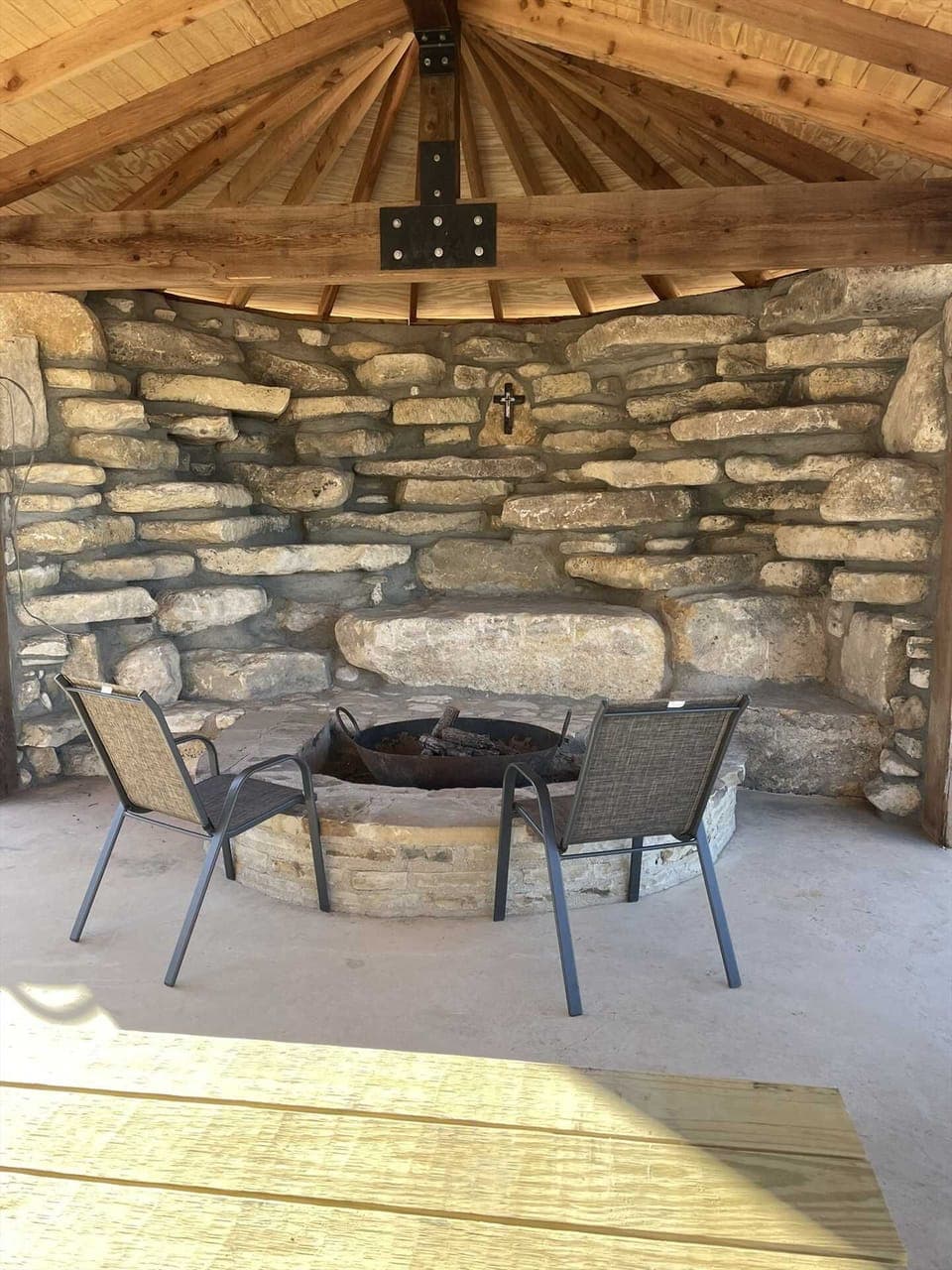 Cozy covered stone fire pit with built-in seating-perfect for relaxing evenings under the warm Texas Hill Country sky.