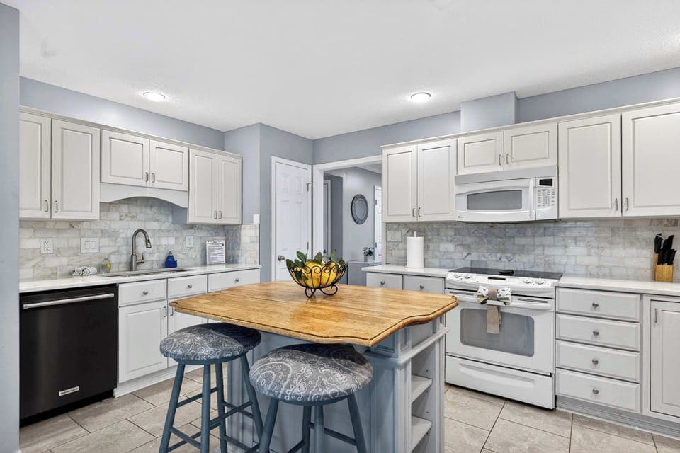 Kitchen: Modern kitchen setup featuring spacious counters, an elegant island counter, and all your cooking basics.