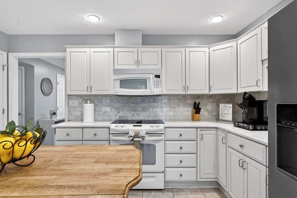 Kitchen: Modern kitchen setup featuring spacious counters, an elegant island counter, and all your cooking basics.