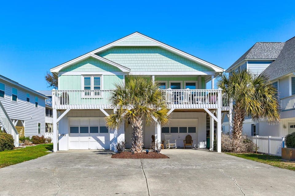 Charming coastal home with tropical palm trees and spacious parking, nestled in a peaceful beach community.