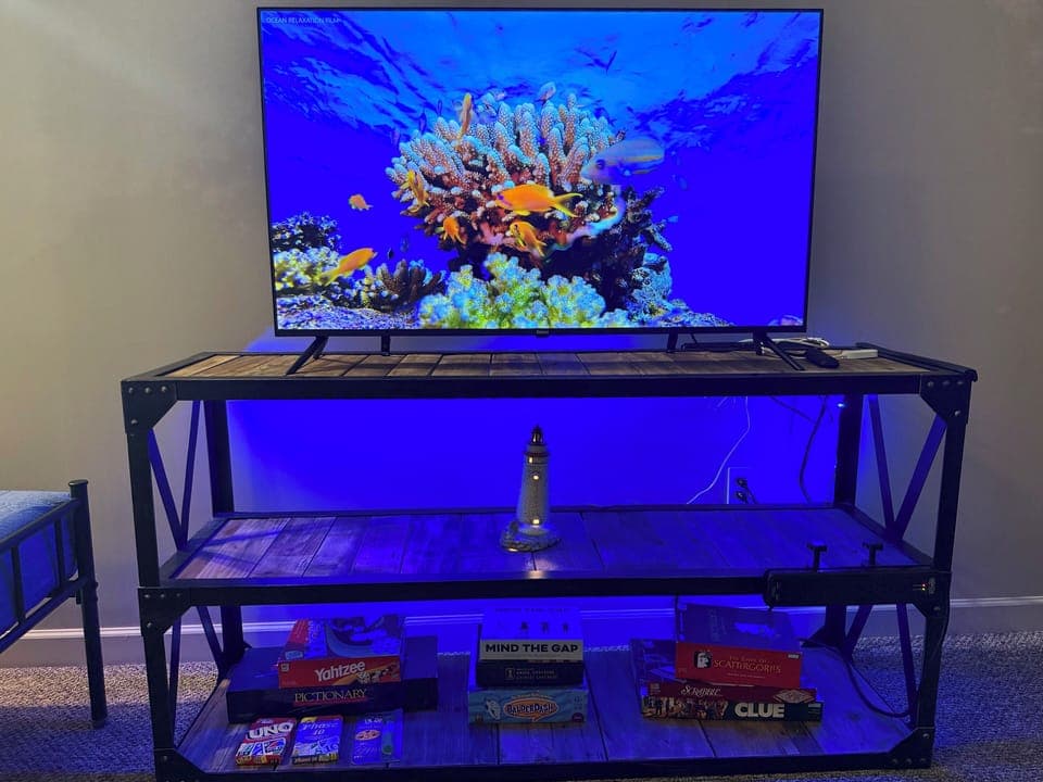 Entertainment setup with large TV, ambient lighting, and a collection of board games—perfect for movie nights or family fun after a day out.